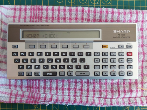 Photo of Sharp PC-1500 Pocket Computer showing the 'NEW0? :CHECK' prompt